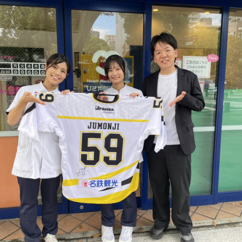 大澤一樹（右）と、サイン入りユニフォームを持つお客様
